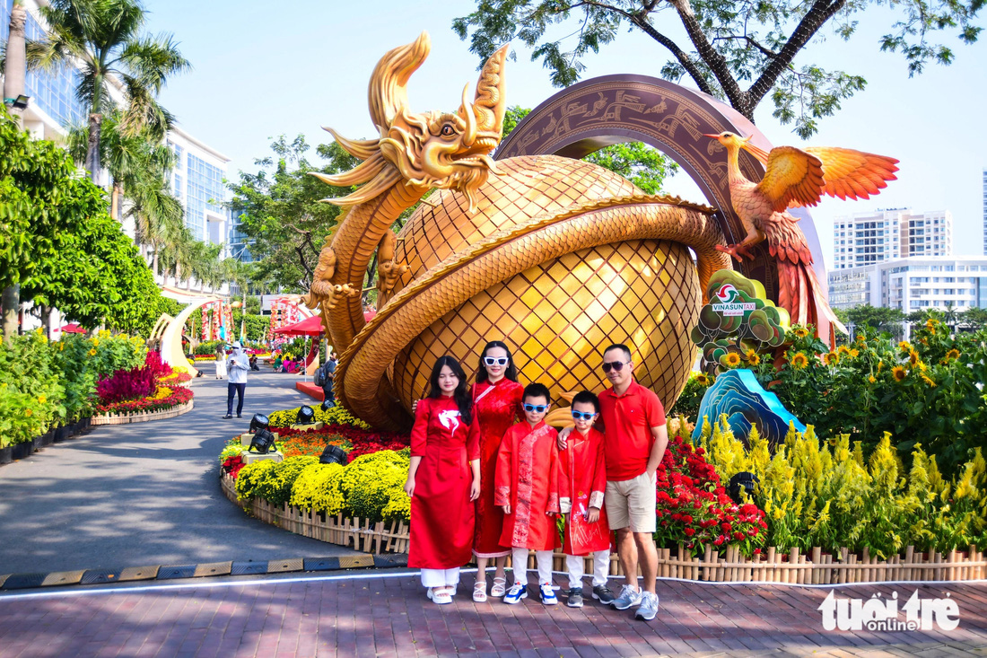 Gia đình chị Thúy An cùng nhau diện sắc đỏ chụp ảnh kỷ niệm tại đường hoa Phú Mỹ Hưng trưa 3-2