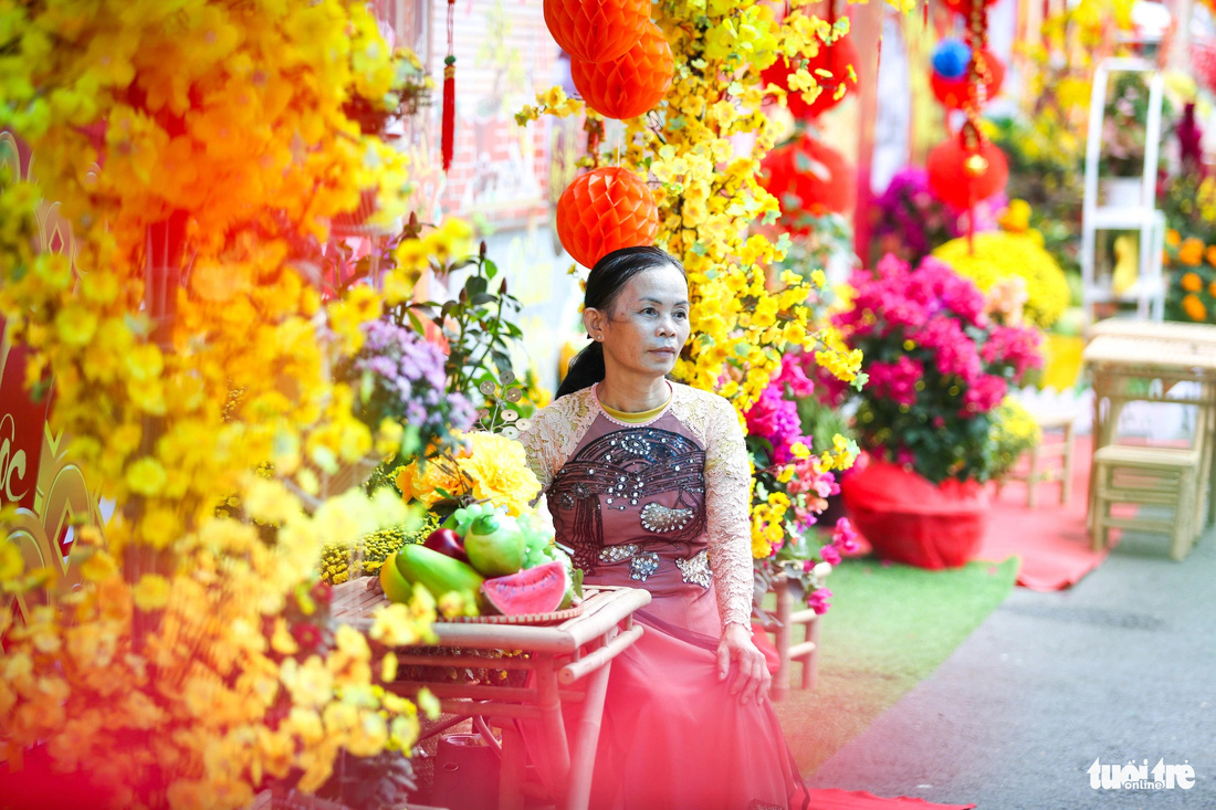 Sau một hồi dạo quanh đường hoa, cô Nguyễn Thị Tiền (quê Tây Ninh) cũng can đảm chọn cho mình một chiếc áo dài và nhờ thợ chụp ảnh kỷ niệm. &quot;Kệ, đường hoa đẹp thế này mà sao mình phải ngại. Cứ chụp đi đã, quan trọng là vui, cô nói.