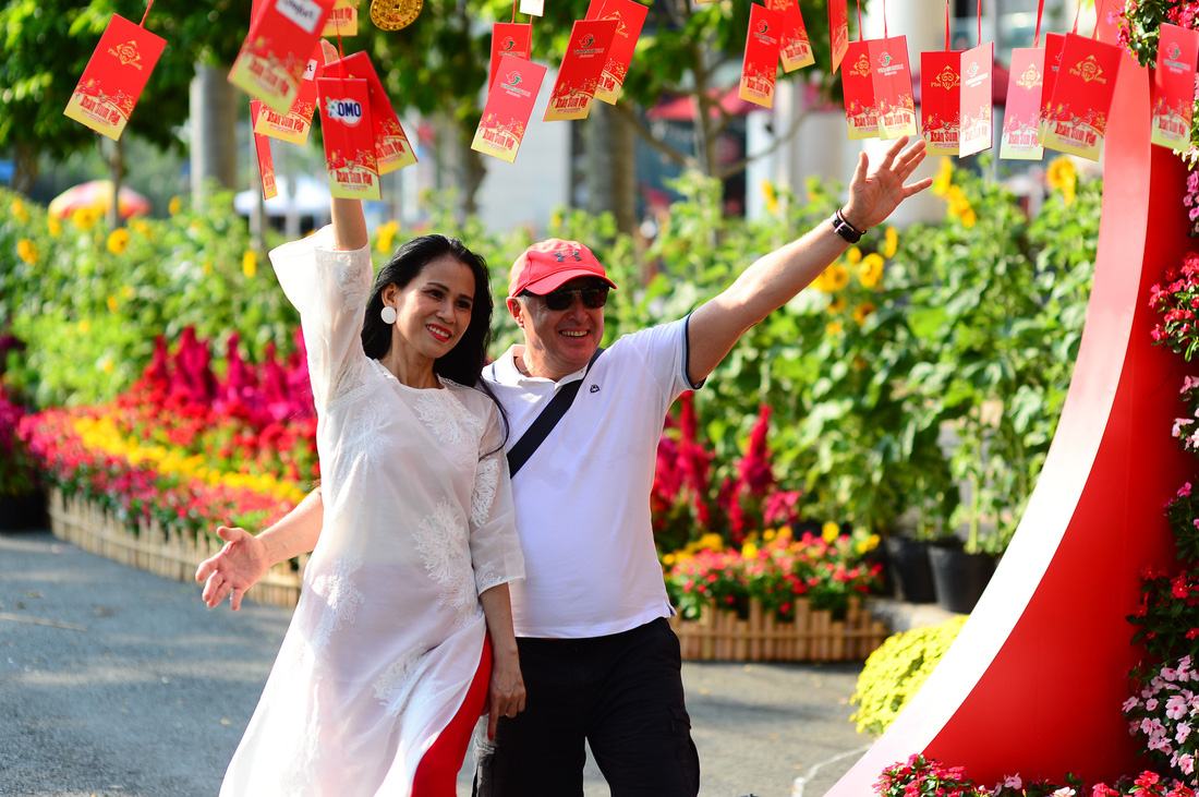 Người dân đi chơi, chụp ảnh lưu niệm ở đường hoa Phú Mỹ Hưng, quận 7, TP.HCM, Tết Giáp Thìn - Ảnh: QUANG ĐỊNH