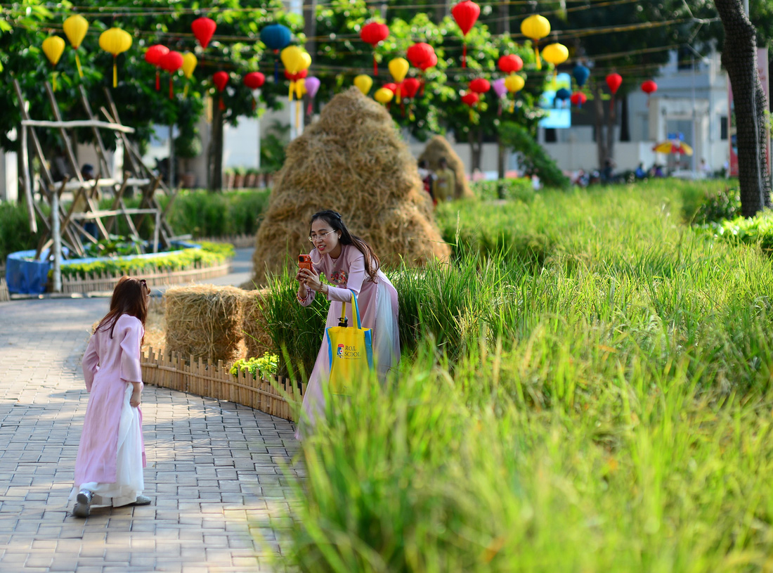 Người dân đi chơi, chụp ảnh lưu niệm ở đường hoa Phú Mỹ Hưng, quận 7, TP.HCM, Tết Giáp Thìn - Ảnh: QUANG ĐỊNH