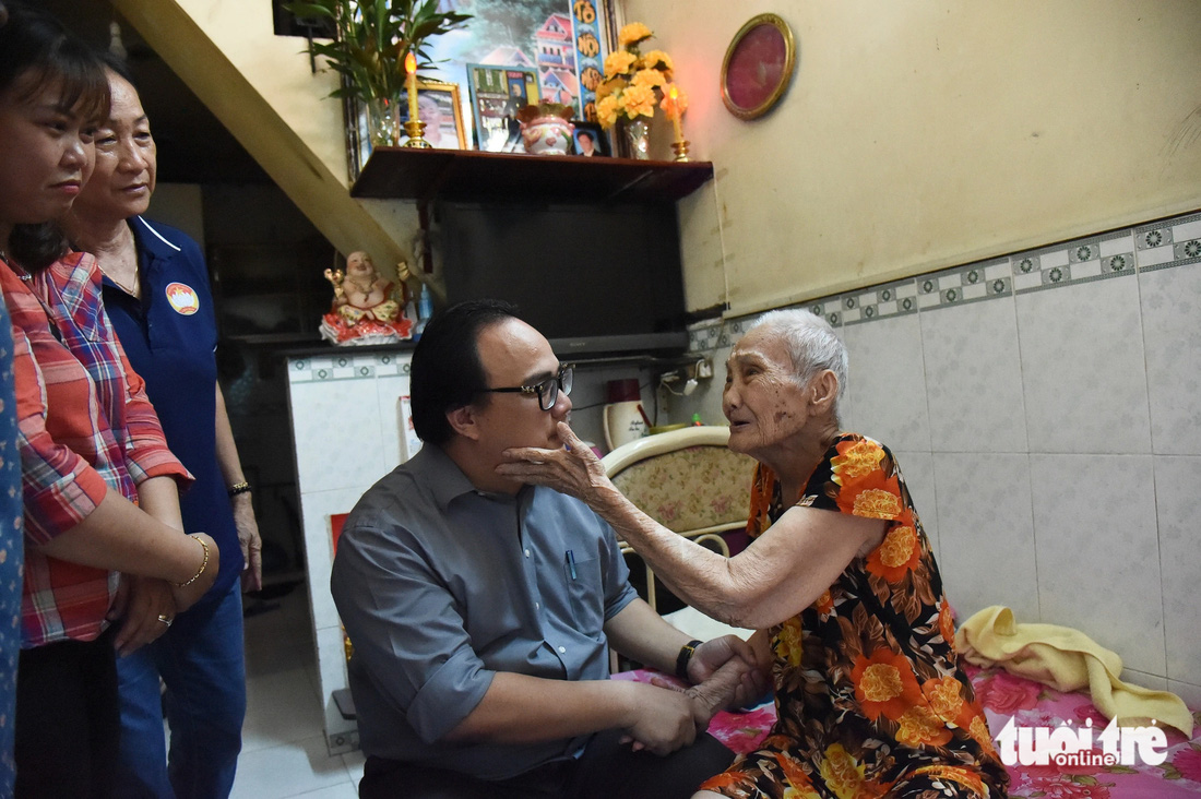 Cụ bà Nguyễn Thị Tám 91 tuổi vui mừng khi anh Nguyễn Thanh Bình - Chủ tịch UBND phường 10 quận 4 - thăm tặng quà tết - Ảnh: HẢI QUỲNH