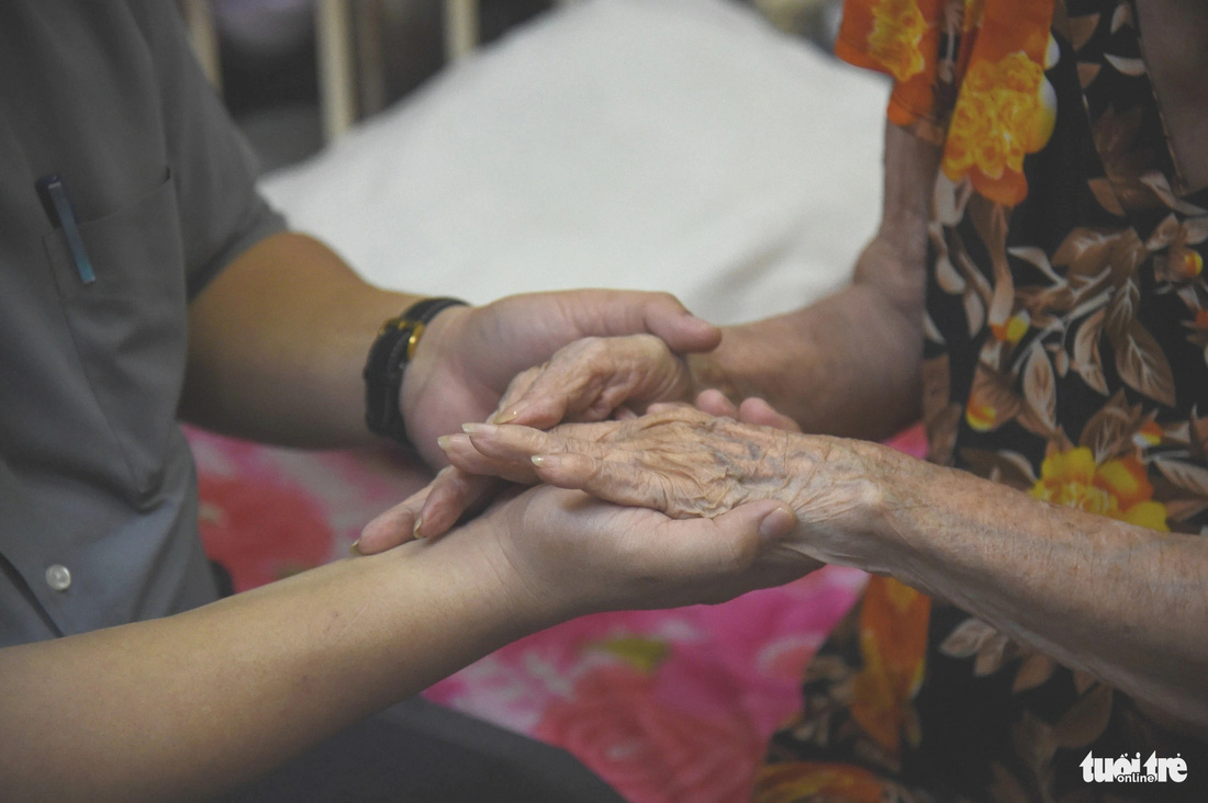 Cụ bà Nguyễn Thị Tám 91 tuổi bịn rịn khi được đoàn đến thăm và tặng quà Tết - Ảnh: HẢI QUỲNH