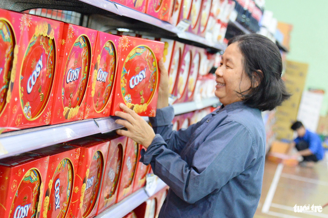 Cô Phạm Thị Trọng Đại, công nhân vệ sinh làm việc tại công ty ở quận 1, vui mừng mua bánh, kẹo, gạo… với giá 0 dồng - Ảnh: HẢI QUỲNH