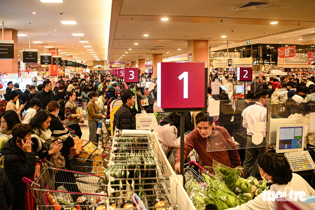 Người dân xếp hàng chờ thanh toán tại một siêu thị chiều 29 Tết - Ảnh: HỒNG QUANG