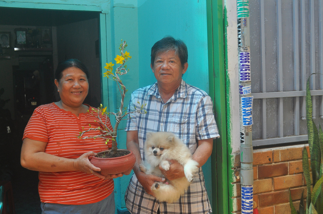 Ông Nguyễn Văn Huy và bà Võ Thị Bích Huyên, cha mẹ của Khánh Phong, cùng với chú cún mà cậu con trai gửi vào từ Hà Nội - Ảnh: ĐỨC KHUÊ