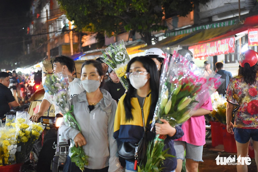 Các bạn trẻ mua hoa tại chợ hoa Đầm Sen, quận 11, TP.HCM - Ảnh: TỰ TRUNG