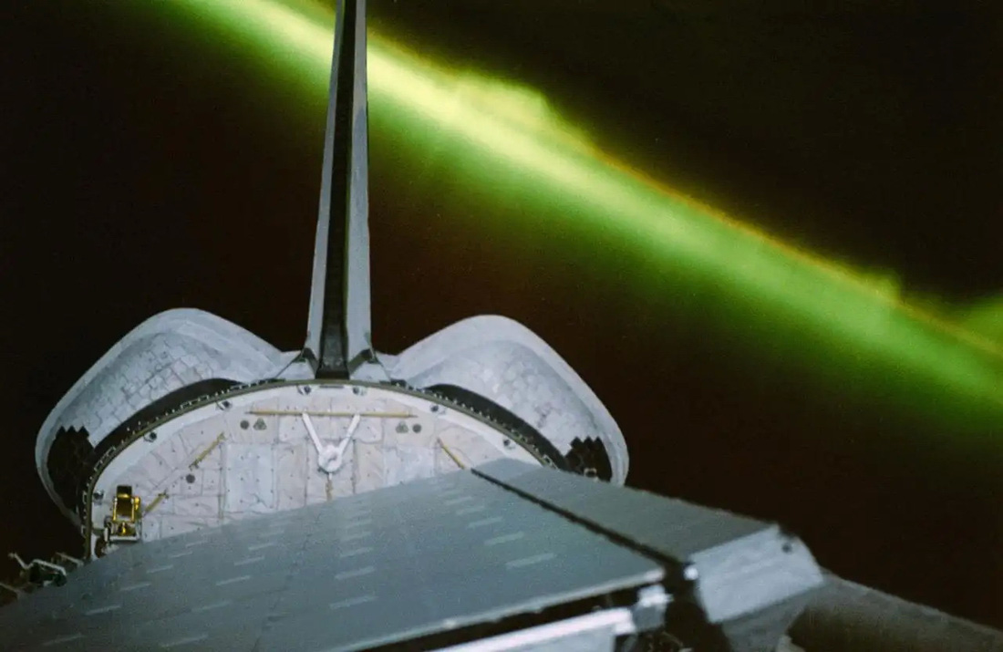 Cực quang xuất hiện màu xanh lục tạo thành phông nền hoàn hảo cho tàu con thoi Endeavour xuất hiện. Endeavour nổi bật trong hình với các ăng ten dành cho thiết bị radar, đang được ánh trăng chiếu sáng. Các phi hành gia đã nhìn thấy cực quang nhiều lần trong suốt 11 ngày thực hiện nhiệm vụ - Ảnh: NASA