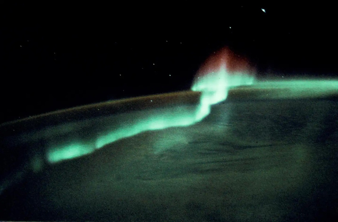 Tiến sĩ Don L.Lind mô tả cảnh tượng này bằng 2 chữ &quot;ngoạn mục&quot;. Khung cảnh được chụp khi tàu vũ trụ nằm trên một điểm nằm giữa Úc và lục địa Nam Cực. Trong bức ảnh, dải màu xanh lam và các tia màu đỏ cao là cực quang. Dải màu nâu song song với đường chân trời của Trái đất là sự phát quang của chính bầu khí quyển và được gọi là ánh sáng không khí - Ảnh: NASA