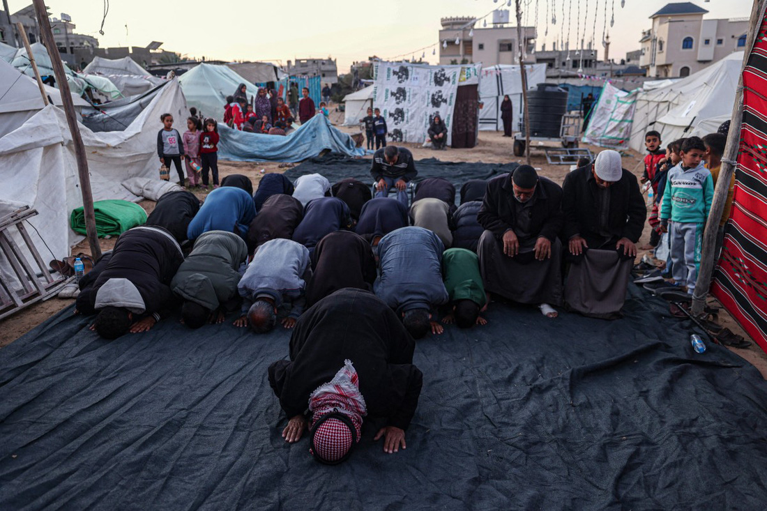 Các tín đồ Hồi giáo người Palestine cầu nguyện ở một trại tị nạn tại thành phố Rafah, miền nam Dải Gaza - Ảnh: AFP