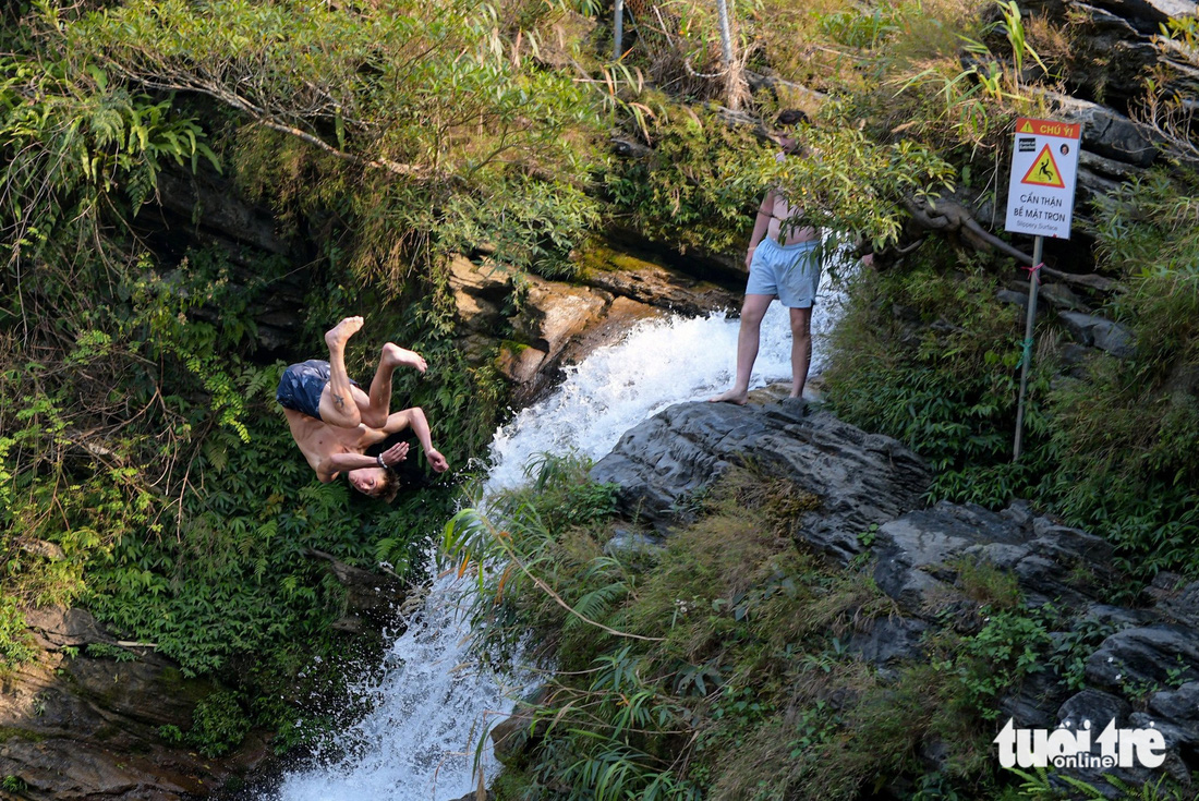 Du khách thích thú nhảy từ trên thác xuống hố nước phía dưới 