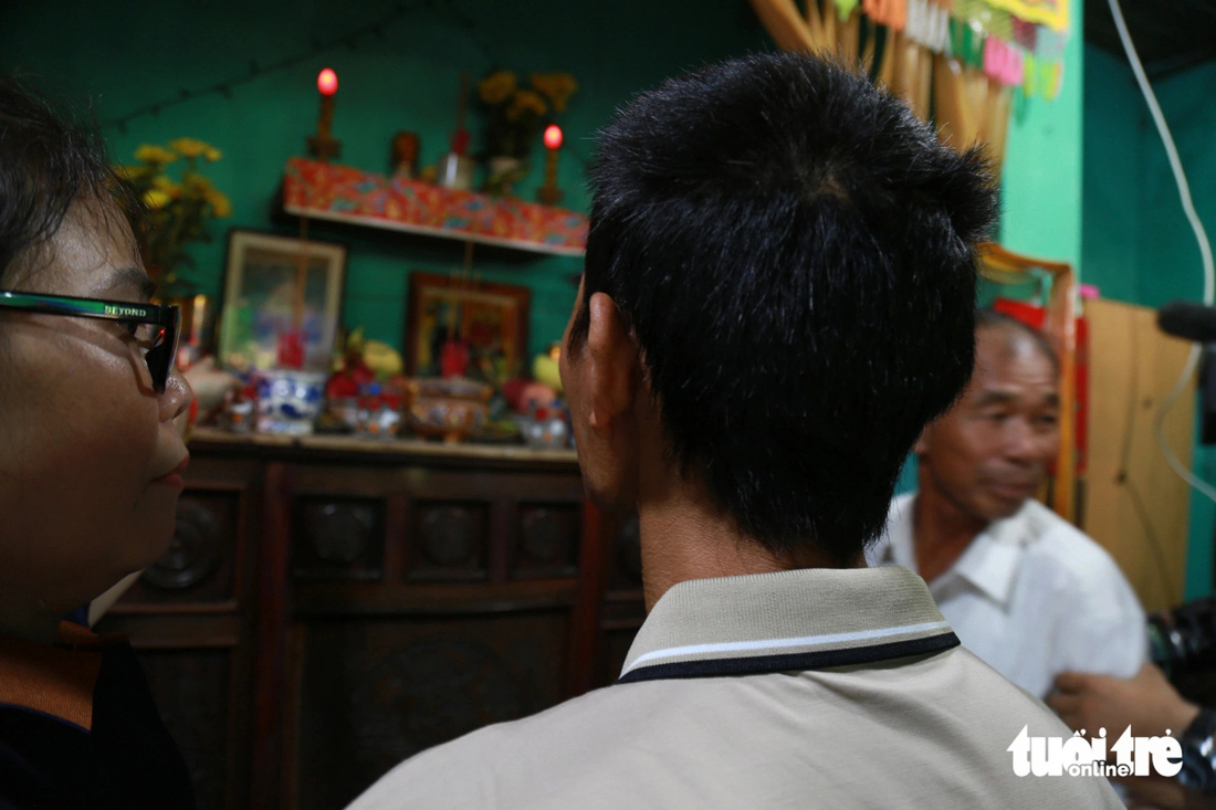 Chị Trần Thị Thảo, chị gái của Chung, dắt em trai đến trước bàn thờ gia tiên để thắp nén nhang trong ngày đoàn tụ - Ảnh: ĐOÀN NHẠN