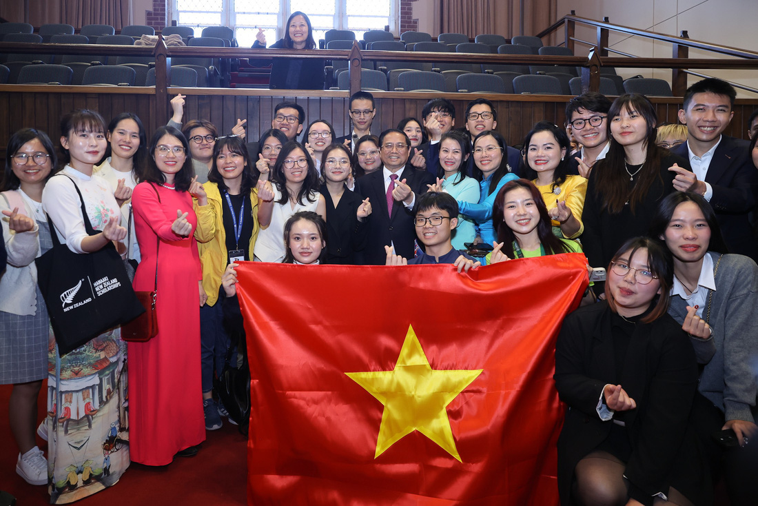Thủ tướng Phạm Minh Chính làm động tác hình trái tim bằng hai ngón tay khi chụp ảnh cùng sinh viên Việt Nam tại Đại học Victoria (New Zealand) ngày 11-3 - Ảnh: NHẬT BẮC