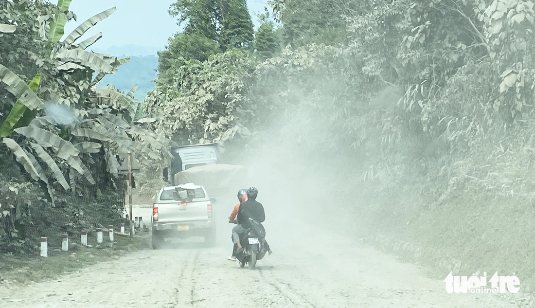 Người đi xe máy khổ sở vì bụi mù mịt khi đi sau xe chở quặng nhôm bauxite 