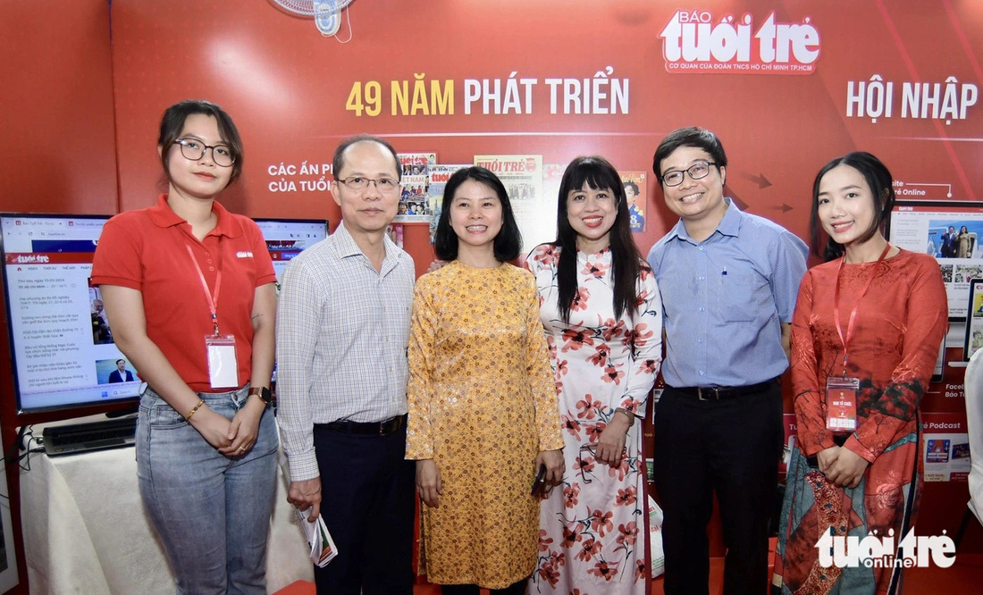 Nhà báo Lê Xuân Trung - phó tổng biên tập báo Tuổi Trẻ (thứ hai, từ trái qua) tiếp khách đến tham quan gian trưng bày - Ảnh: QUANG ĐỊNH