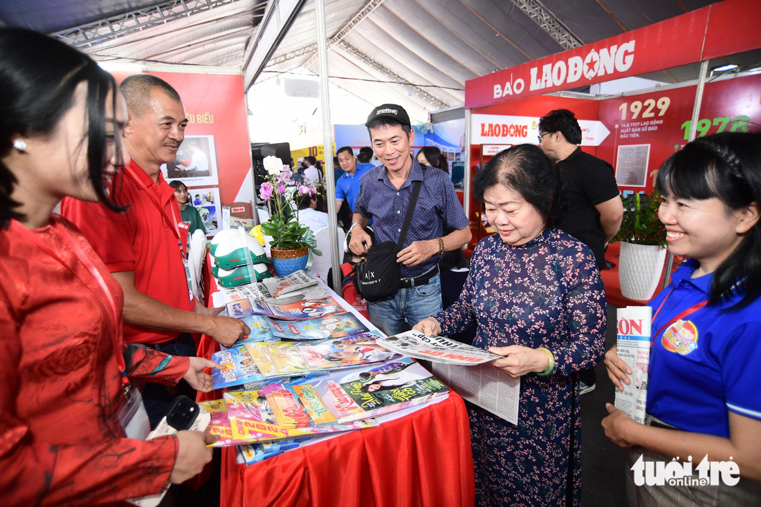 Bà Trương Mỹ Hoa - nguyên phó chủ tịch nước (áo dài) - đọc các ấn phẩm của Tuổi Trẻ - Ảnh: QUANG ĐỊNH