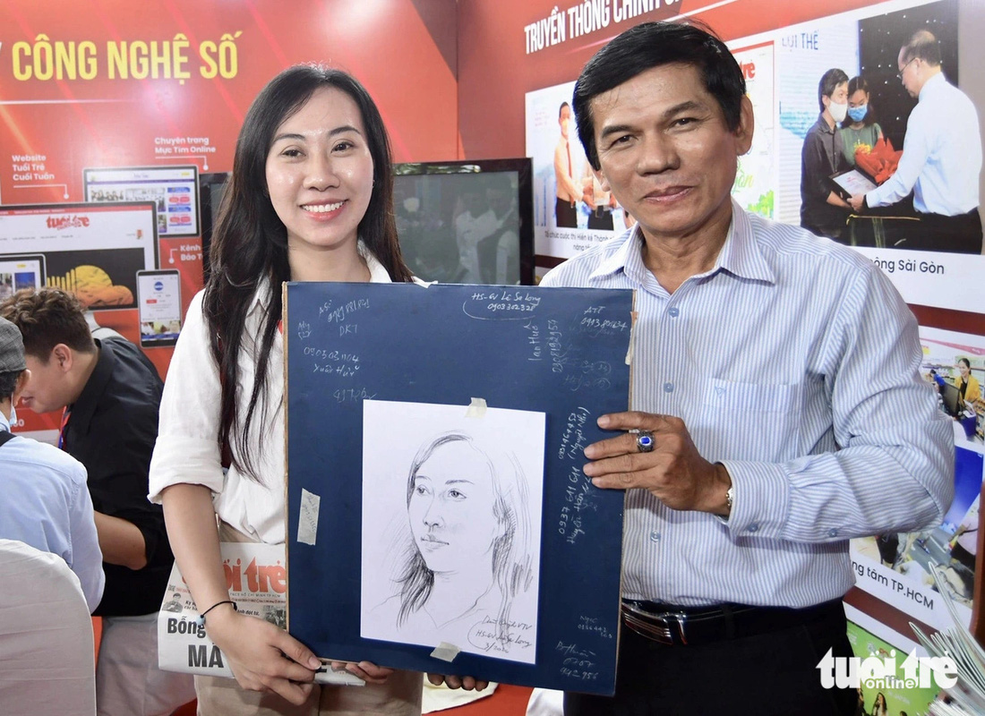 Họa sĩ Lê Sa Long trao tặng tranh chân dung cho bạn đọc Tuổi Trẻ - Ảnh: QUANG ĐỊNH
