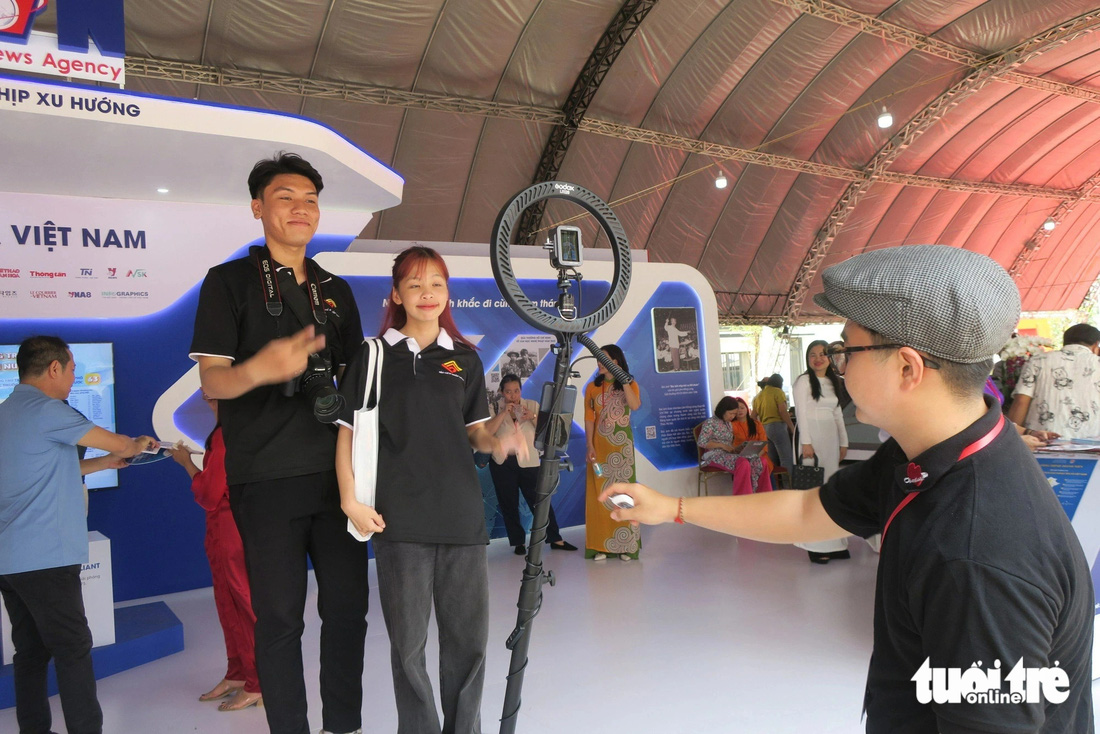 Bạn trẻ trải nghiệm chụp ảnh 360 độ tại gian hàng Thông tấn xã Việt Nam - Ảnh: T.T.D