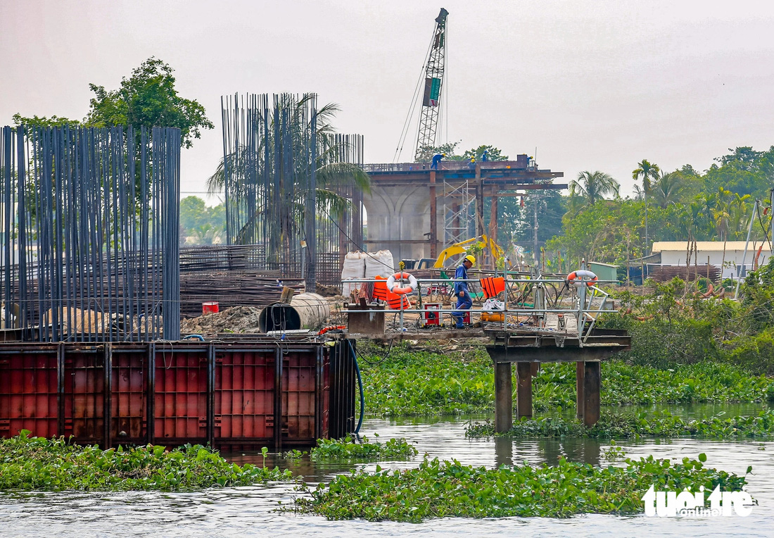 Trong ảnh là công trường vành đai 3, đoạn qua huyện Củ Chi (TP.HCM, cách công trường phía bên kia sông của tỉnh Bình Dương) cũng đang hoạt động nhộn nhịp - Ảnh: ĐỨC PHÚ