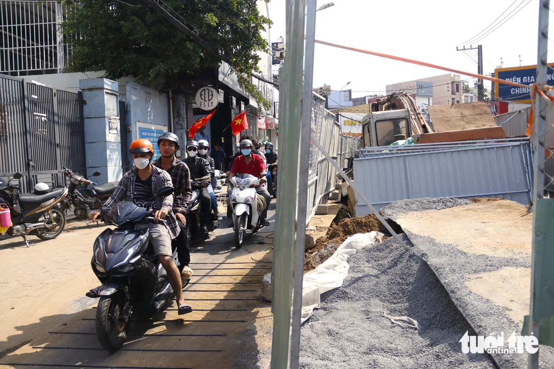 Cát, đá tại công trình phủ lên các tấm thép là điều khó tránh khỏi nên khi đi qua người dân phải hết sức cẩn thận - Ảnh: TIẾN QUỐC