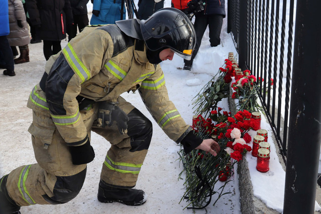 Lính cứu hỏa tại vùng Chukotka đặt hoa tưởng niệm các nạn nhân vụ xả súng sáng 23-3 - Ảnh: RIA NOVOSTI