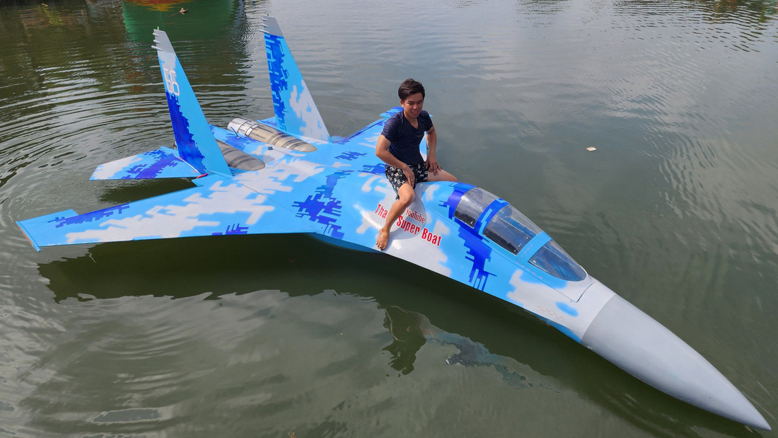 Anh Thanh bên mô hình máy bay chiến đấu Su-35 của Nga được anh chế tạo chạy trên sông nước - Ảnh: HOÀNG THANH