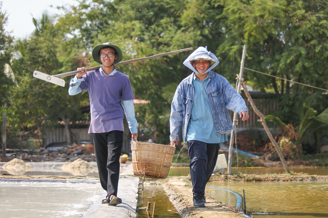 Lần đầu Thiên Bảo (phải) được trải nghiệm cùng người dân làm muối, một nghề truyền thống ở đây