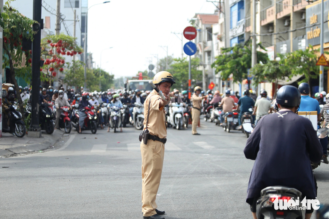 Lực lượng cảnh sát giao thông TP Thủ Đức căng mình điều tiết giao thông, phân luồng - Ảnh: MINH HÒA