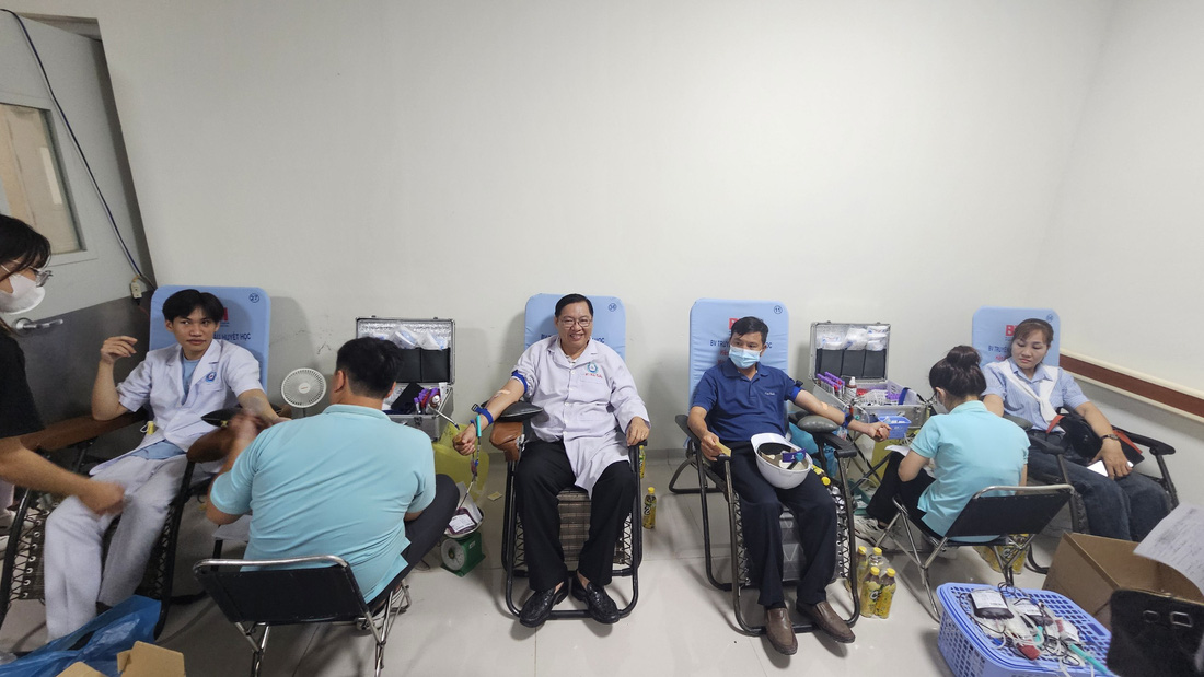 Ông Nguyễn Trần Hữu Tuấn - phó giám đốc Bệnh viện Đa khoa khu vực Hóc Môn (giữa) - cùng với nhân viên y tế tham gia hiến máu nhân đạo - Ảnh: BVCC