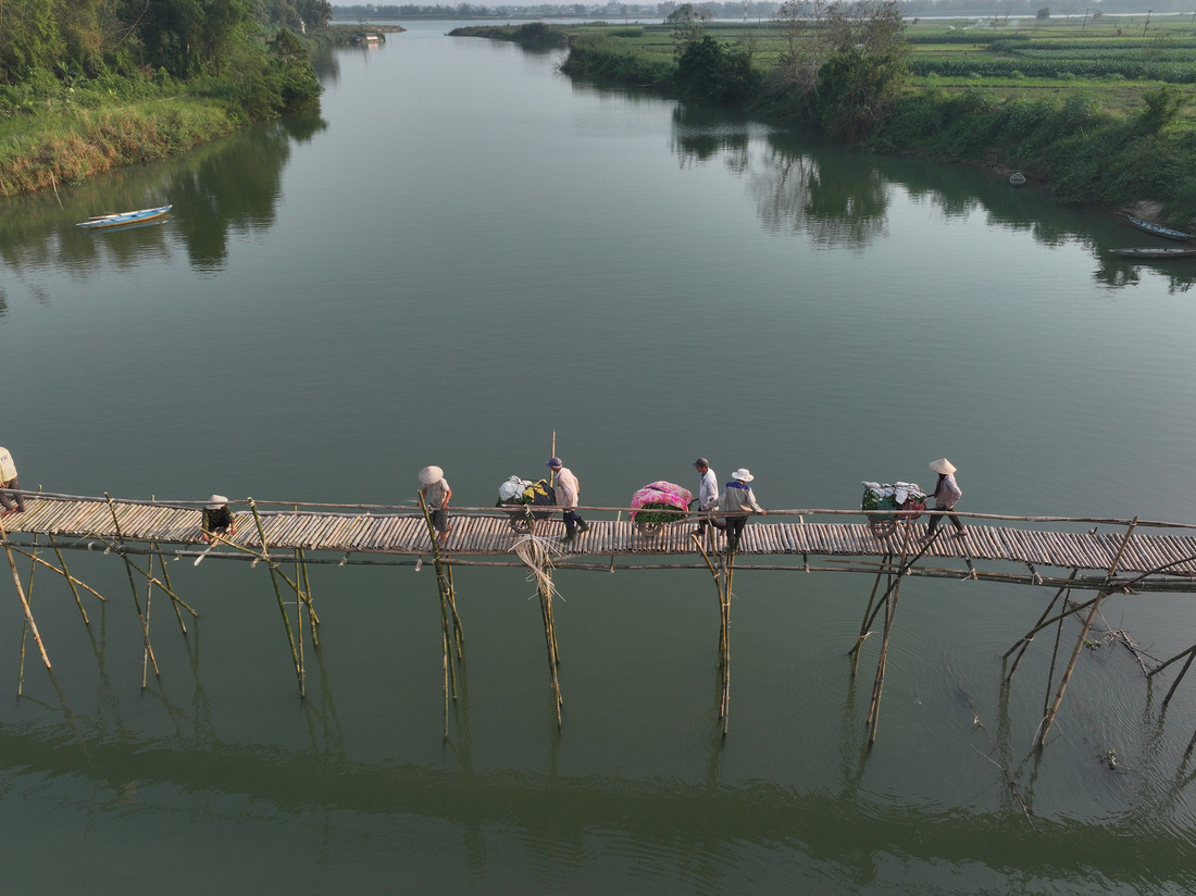 Người dân chở nông sản qua sông sau khi cầu hoàn thành