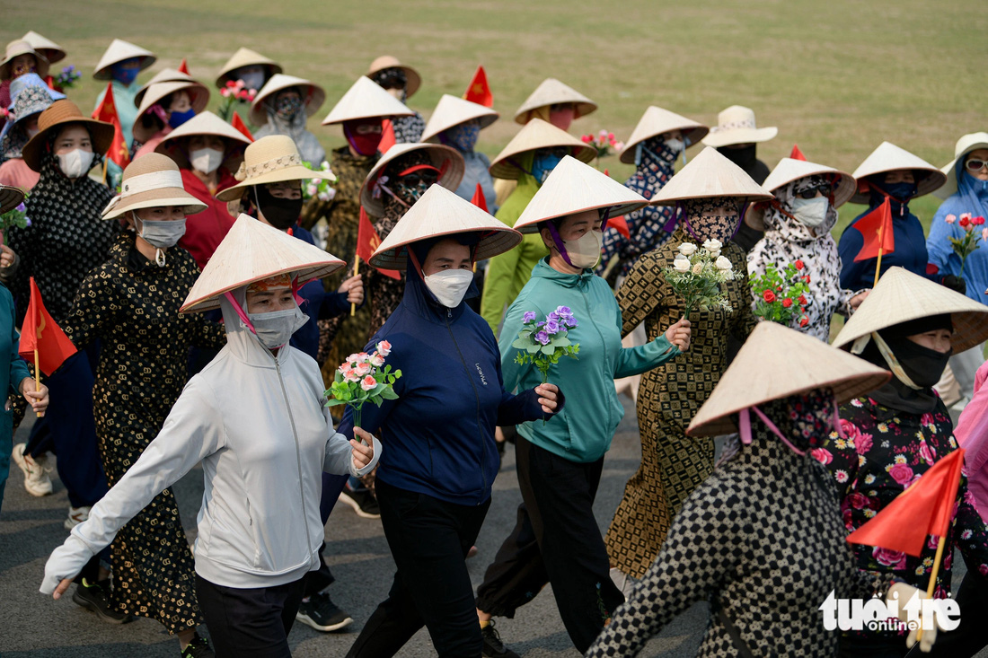 Các cô, các chị với chiếc nón lá, áo chống nắng tập luyện giữa cái nắng oi bức tại sân vận động Điện Biên Phủ trưa 12-4