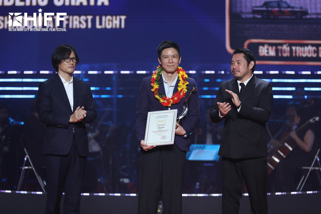 Đạo diễn Bảo Nguyễn trao giải Quay phim xuất sắc nhất cho ông Hideho Urata với phim Last shadow at first light (Đêm tối trước bình minh, Singapore) - Ảnh: HIFF