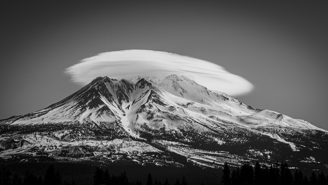 “Đám mây dạng thấu kính trên núi Shasta”. Nằm ở phía bắc California, núi Shasta là một ngọn núi lửa dạng tầng có bốn đỉnh với độ cao chỉ hơn 4.300 mét. Những đám mây dạng thấu kính hình thành trên núi quanh năm và tác giả chụp bức ảnh đặc biệt này vào mùa xuân. Tác giả muốn ghi lại vẻ hùng vĩ tổng thể của ngọn núi, nhưng cũng muốn nhìn thấy bên dưới đám mây nơi các đỉnh núi đang ẩn náu - Ảnh: Lisa K. Kuhn, Mỹ