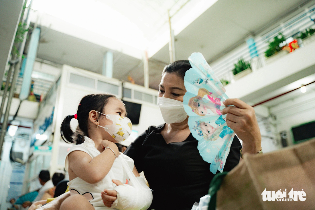 Chị Lan (quận 5) dẫn con gái đi tái khám tại Bệnh viện Chấn thương chỉnh hình. Hơi nóng từ mái tôn phả xuống khiến hai mẹ con toát mồ hôi
