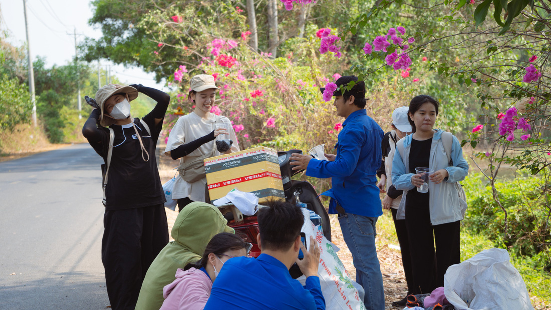 Cán bộ đoàn viên hỗ trợ tiếp nước cho các bạn trẻ nhặt rác - Ảnh: MINH ĐĂNG