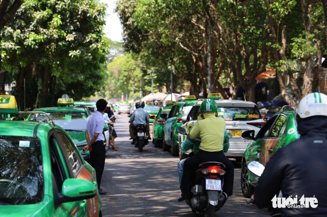 Xe máy luồn lách, di chuyển khó khăn trên đường A75 Bạch Đằng (phường 2, quận Tân Bình), cạnh sân bay Tân Sơn Nhất do đường bị taxi lấn chiếm để đậu xe - Ảnh: NGỌC QUÝ