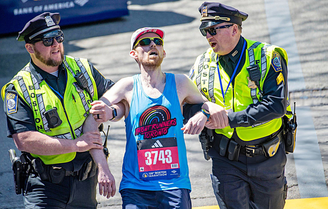 Một VĐV tham dự Boston Marathon hôm 15-4 được cảnh sát giúp đỡ khi về đích - Ảnh: Getty