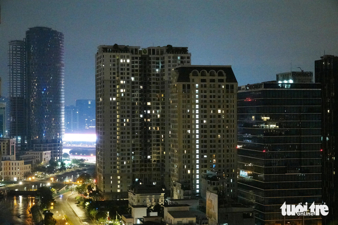 Những căn hộ chung cư ở quận 4 hướng nhìn sông Sài Gòn lãnh luồng ánh sáng chói lòa cả một góc trời. Ảnh chụp lúc 0h55 ngày 2-4 - Ảnh: T.T.D.