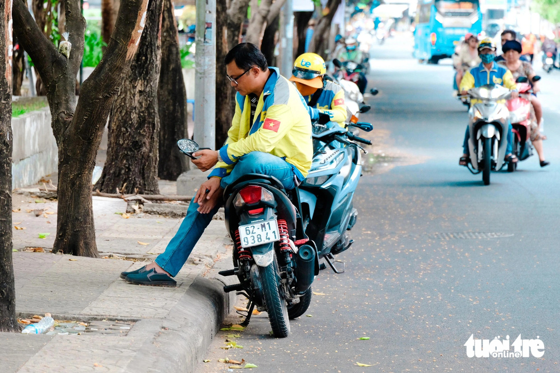 Nhiều người tận dụng bóng mát của hàng cây xanh trên đường Lê Lai làm nơi nghỉ trưa, tránh nắng - Ảnh: PHƯƠNG NHI