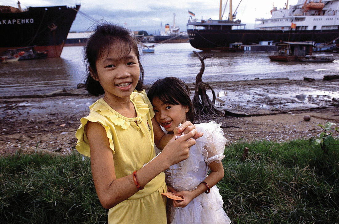 Hai cô bé cười tươi ở Thủ Thiêm, cạnh sông Sài Gòn