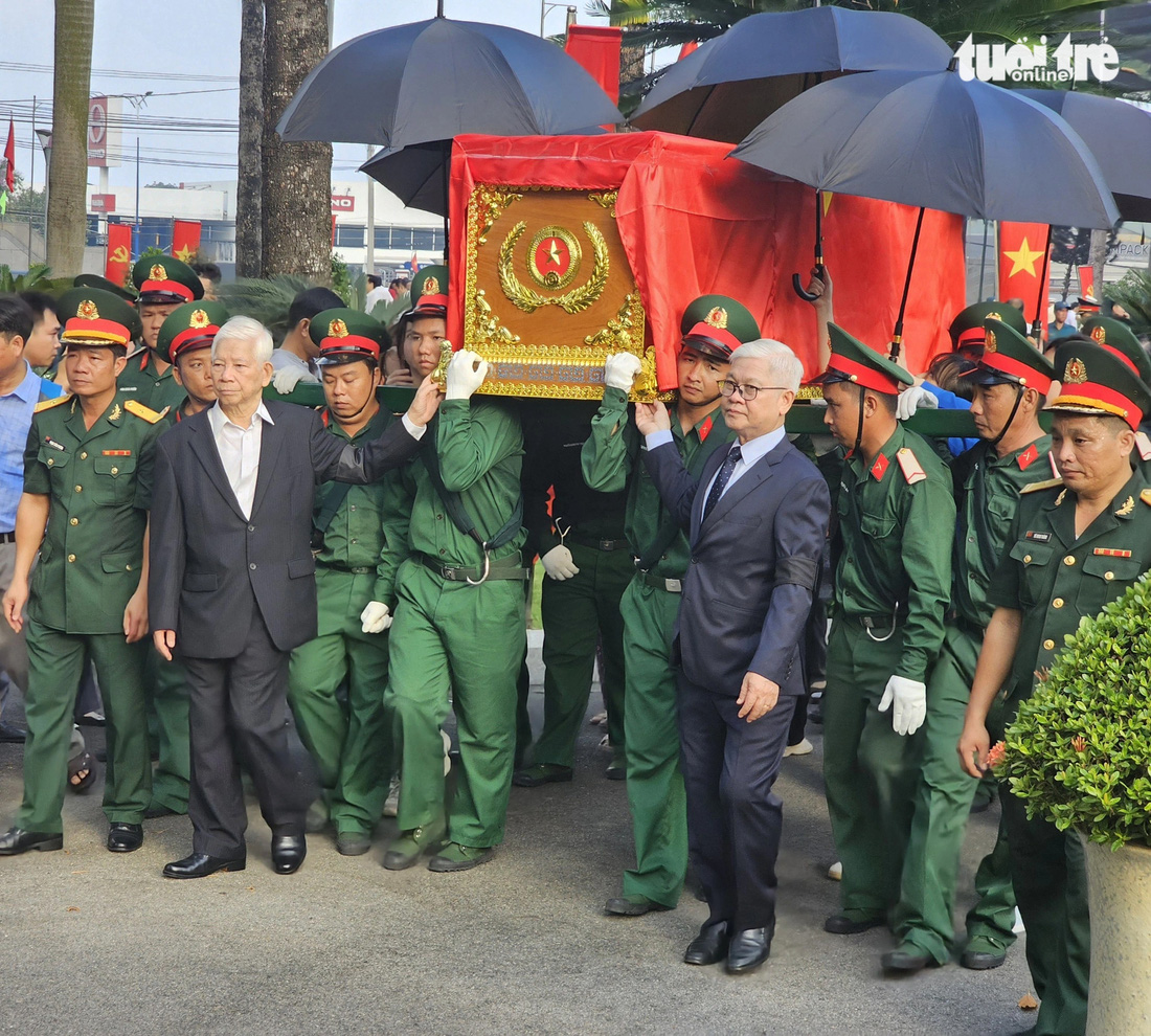 Nguyên Chủ tịch nước Nguyễn Minh Triết (thứ hai từ trái qua) và Bí thư Tỉnh ủy Bình Dương Nguyễn Văn Lợi di quan hài cốt liệt sĩ