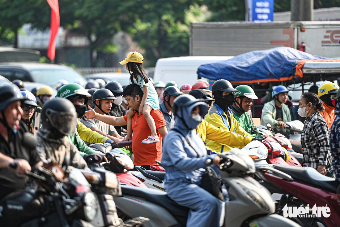 Người đi bộ vất vả len qua dòng xe kẹt cứng để sang đường - Ảnh: HỒNG QUANG