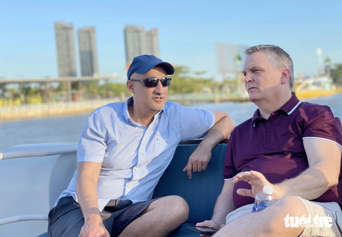Deux touristes américains, M. Michael Malhotra (à gauche) et M. Earl Bruce, ont déclaré que la sensation de regarder la ville depuis la rivière était très merveilleuse. Ils ont également dit qu'être au Vietnam était très amusant, que c'était une période extrêmement significative pour eux deux.