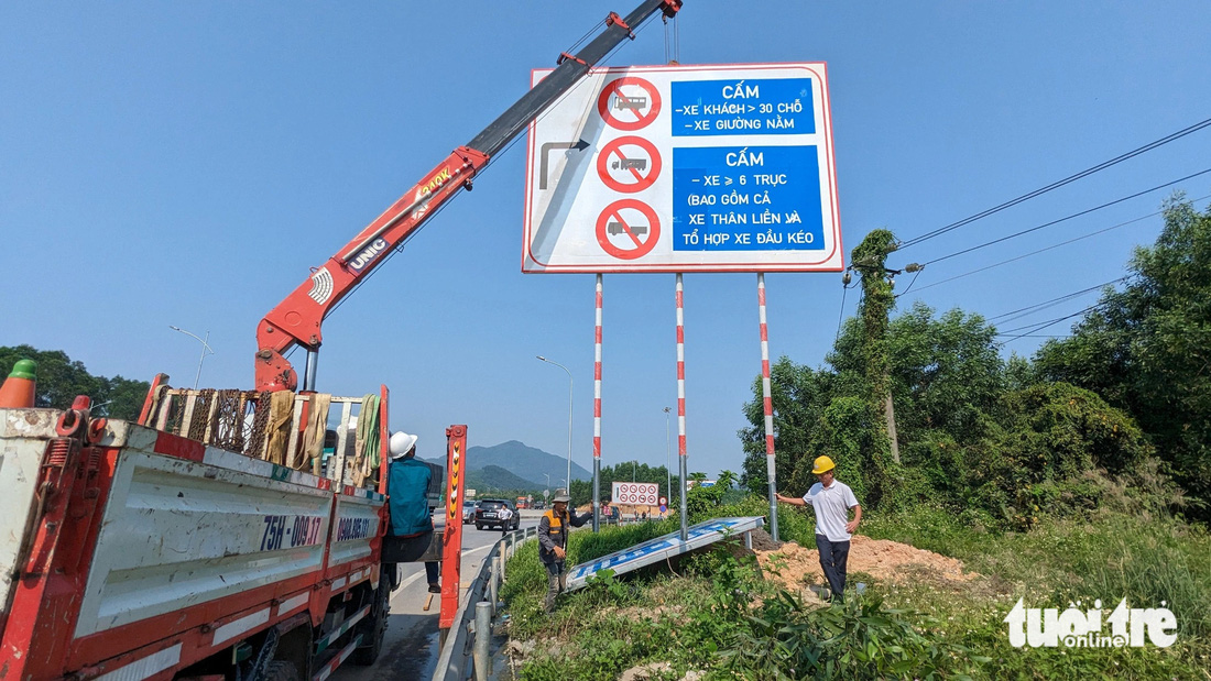 Ban quản lý đường Hồ Chí Minh cắm biển báo cấm một số loại xe tại nút Cầu Tuần dẫn lên cao tốc Cam Lộ - La Sơn - Ảnh: NHẬT LINH