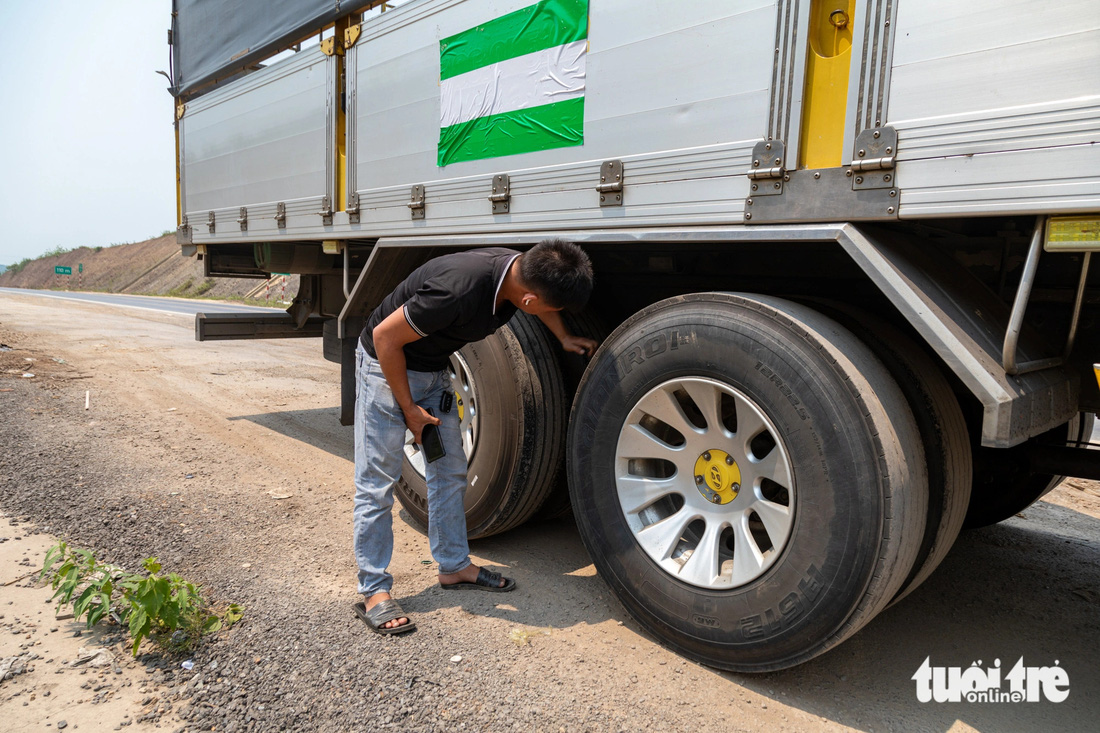 Một tài xế dừng nghỉ, kiểm tra lốp xe trên cao tốc Cam Lộ - La Sơn - Ảnh: HOÀNG TÁO