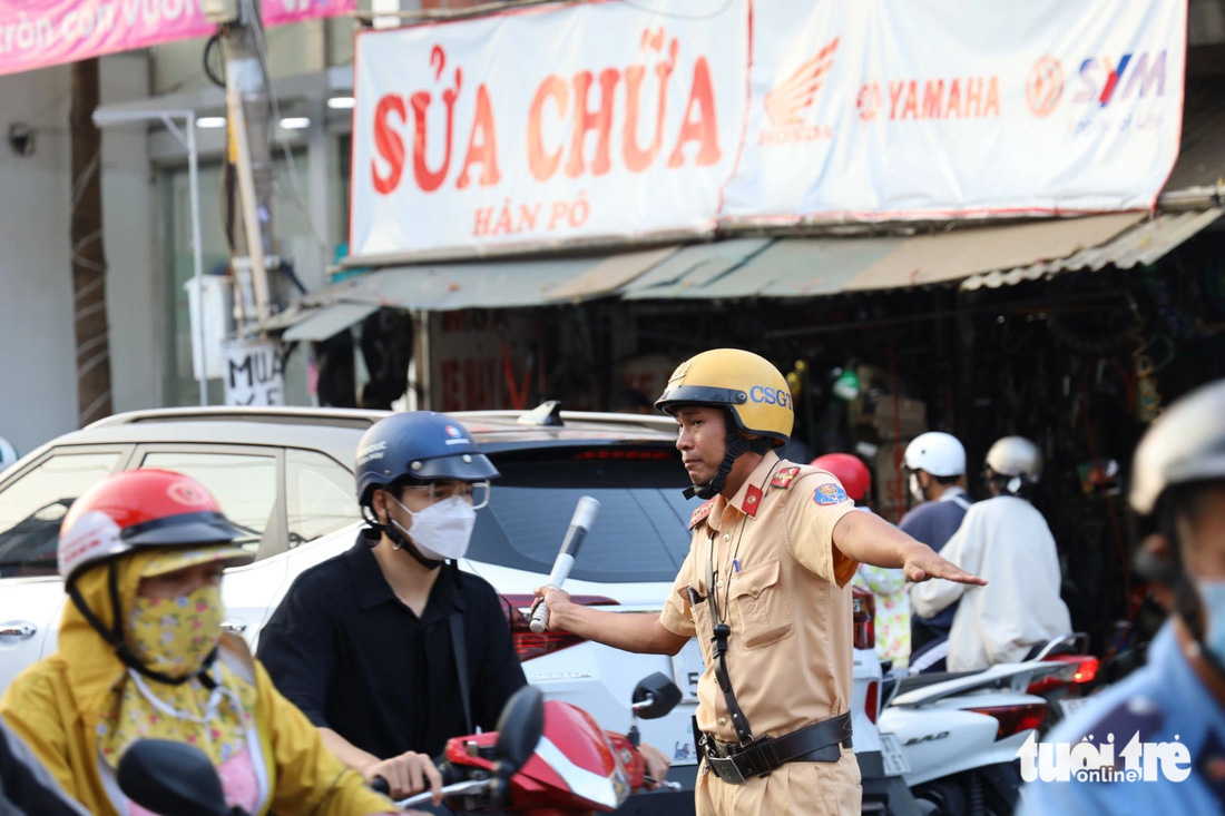 Lực lượng cảnh sát giao thông thường xuyên phải túc trực điều phối lượng xe cộ qua giao điểm Lê Văn Việt và Đình Phong Phú - Ảnh: NGỌC QUÝ
