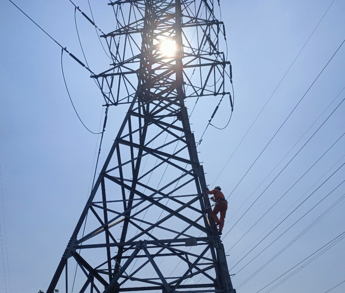 Thợ điện đường đây treo mình dưới cái nắng 40 độ ở Quảng Trị - Ảnh: Quốc Ân