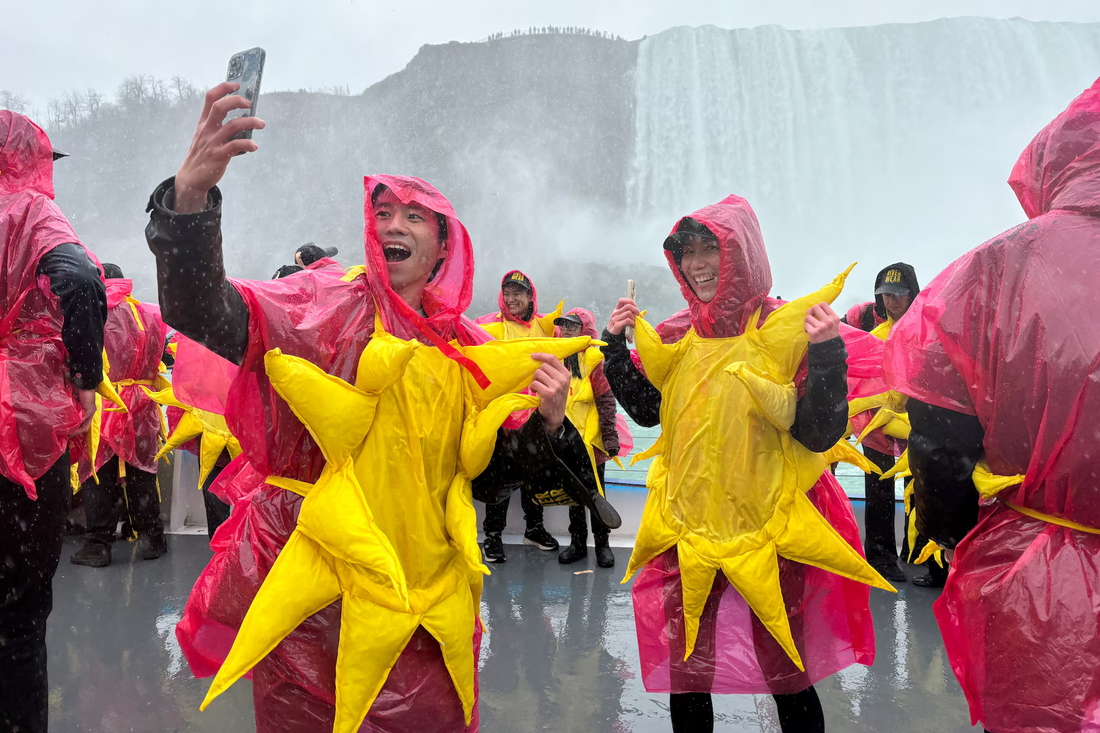 Một nhóm trong số 309 người hóa trang thành mặt trời tập trung ở khu vực thác Niagara, Canada để lập kỷ lục Guinness thế giới - Ảnh: Reuters