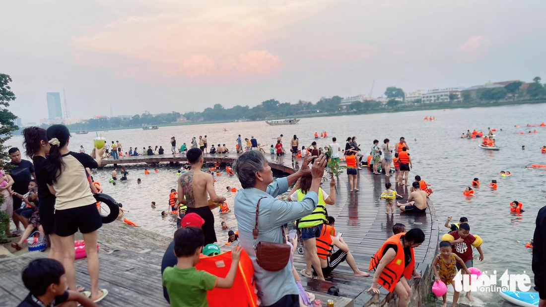 Khoảng 16h chiều, rất nhiều người dân và du khách tìm đến cầu Bán Nguyệt ở bờ bắc sông Hương để giải nhiệt - Ảnh: BẢO PHÚ