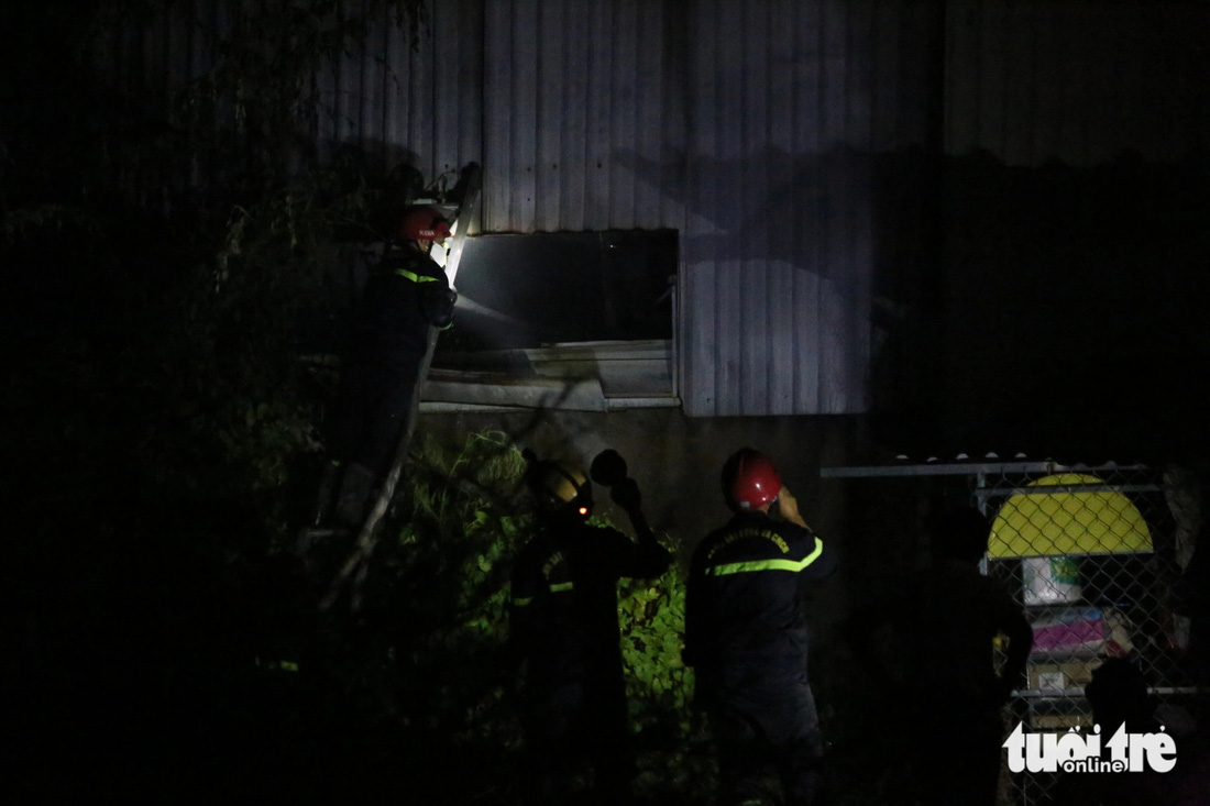 Lực lượng chữa cháy phá tôn nhà xưởng để khói tỏa ra bớt - Ảnh: MINH HÒA