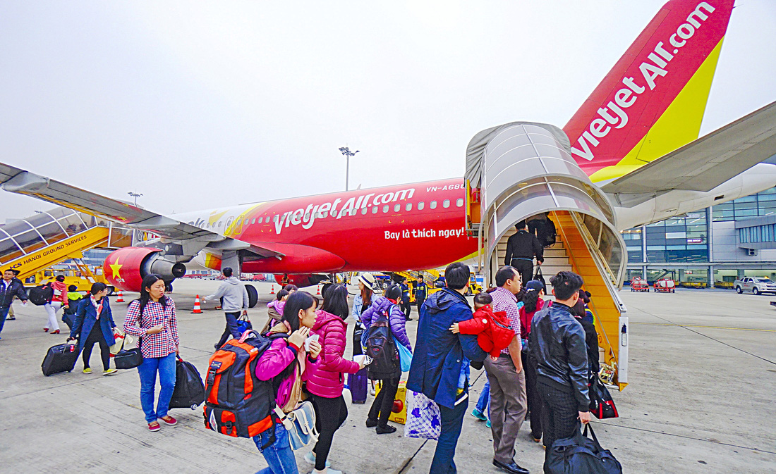 Hành khách lên máy bay của Hãng hàng không VietJet Air tại sân bay quốc tế Tân Sơn Nhất - Ảnh: QUANG ĐỊNH
